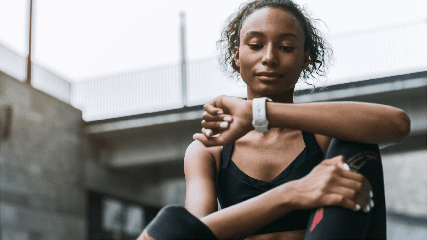 female athlete setting fitness tracker smart watch