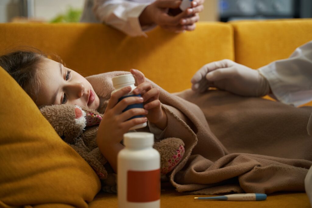 Girl with illness holding medicine bottle at home