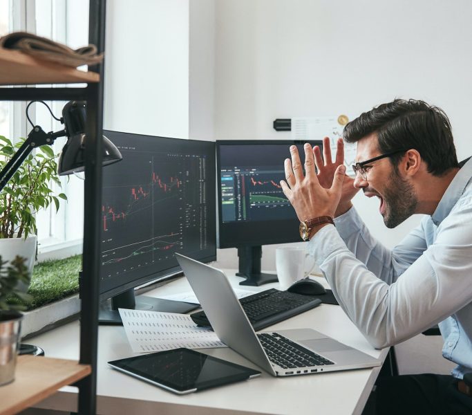 Failing Frustrated young businessman or trader in formalwear is shouting and feeling angry while