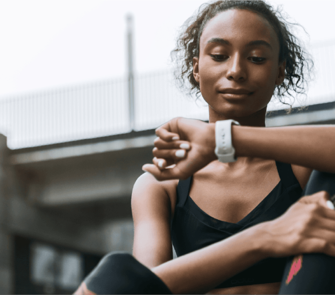female athlete setting fitness tracker smart watch