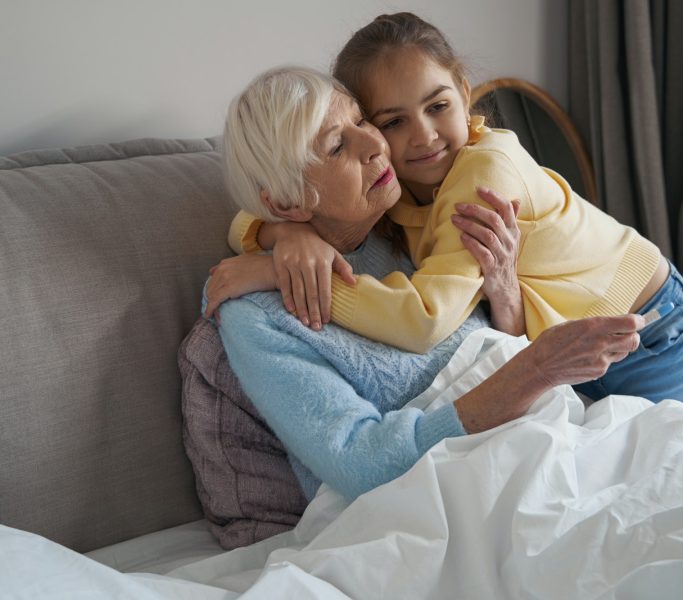 Grandma not feeling well and receiving loving embrace from kid